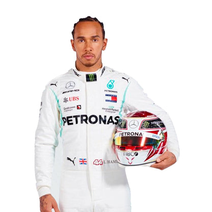Person wearing a white racing suit with sponsor logos, holding a helmet.